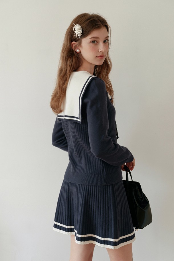 네이비 칼라 니트 가디건은 여성스러운 분위기를 자아내는 상의입니다. 부드러운 니트 소재로 제작되어 편안한 착용감을 선사하며, 세일러 칼라 디자인과 리본 디테일이 돋보입니다. 레귤러 핏에 긴소매 기장으로 봄, 가을에 활용하기 좋으며, 네이비와 화이트 컬러 배색으로 클래식하고 우아한 스타일을 연출합니다. 데이트룩, 모임룩, 소개팅룩 등 다양한 TPO에 매치하여 걸리시하고 미니멀한 스타일을 완성해보세요.
