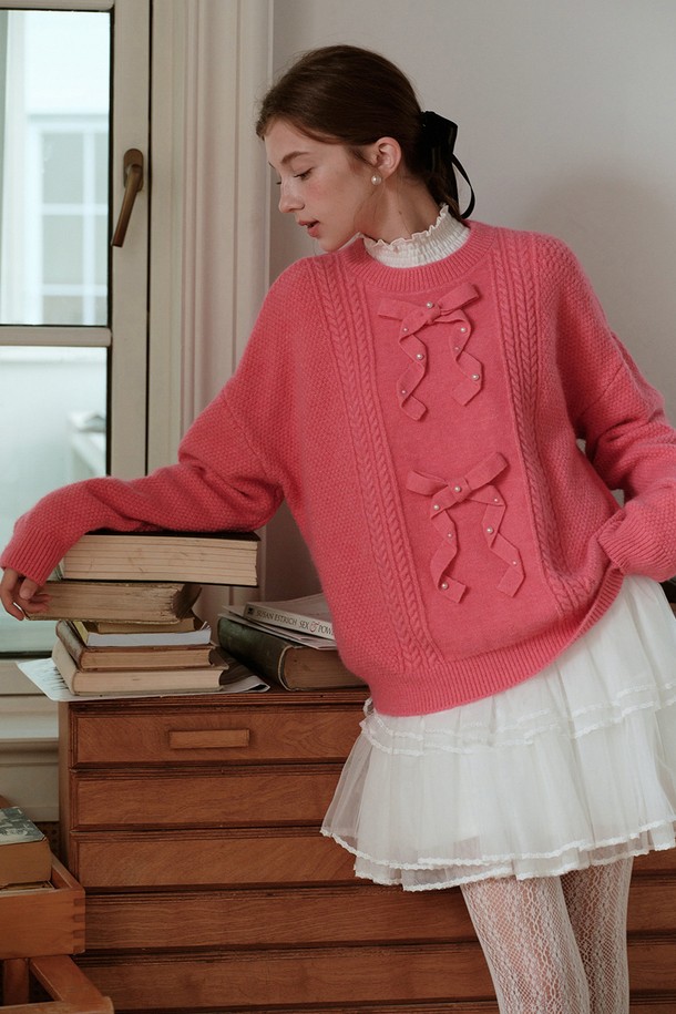 진주 리본 니트 풀오버 스웨터는 가을과 겨울에 따뜻함과 우아함을 선사하는 여성용 니트/스웨터입니다. 핑크 컬러에 케이블 패턴, 레귤러 핏, 라운드넥 디자인으로 부드러운 촉감을 자랑하며, 두꺼운 두께로 보온성을 높였습니다. 

긴 소매와 프릴 디테일, 리본 장식, 진주 장식으로 로맨틱하고 우아한 분위기를 연출하여 데이트룩, 모임룩에 적합합니다. 캐주얼, 클래식, 로맨틱 스타일을 모두 소화할 수 있는 활용도 높은 아이템입니다.
