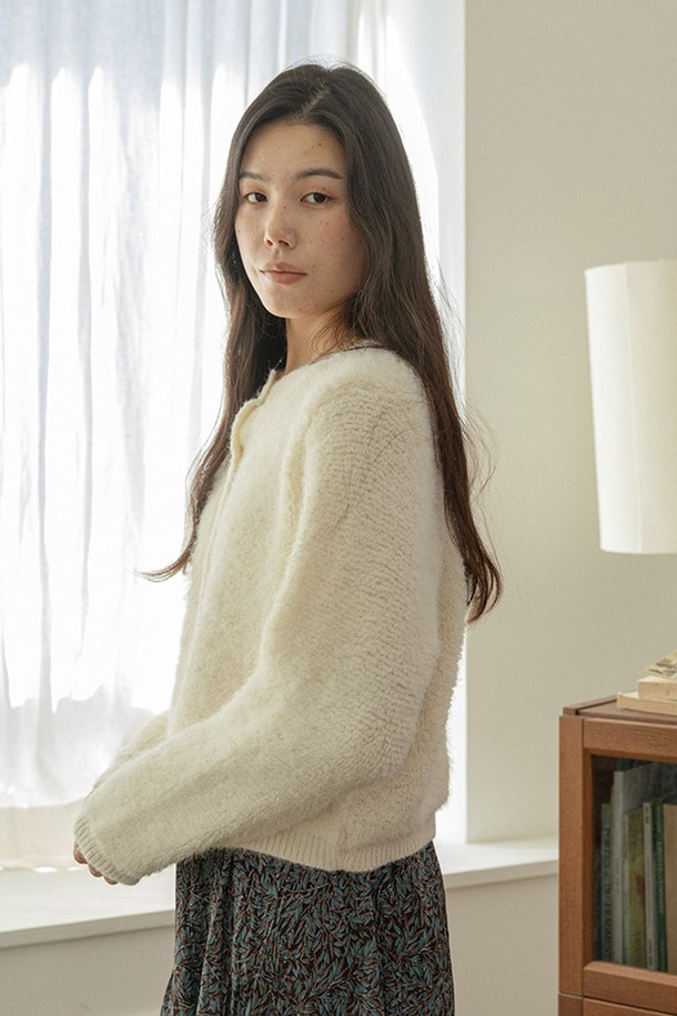 플러시 니트 카디건_아이보리는 부드러운 촉감의 플러시 소재로 제작되어 포근한 착용감을 선사합니다. 라운드넥 디자인에 긴 소매 기장으로, 가을과 겨울철에 따뜻하게 입을 수 있습니다. 베이직하고 캐주얼한 스타일로, 집콕룩이나 산책룩 등 다양한 TPO에 활용하기 좋습니다. 루즈핏 크롭 기장으로 편안하면서도 스타일리시한 연출이 가능하며, 무지 디자인으로 미니멀한 분위기를 더합니다.
