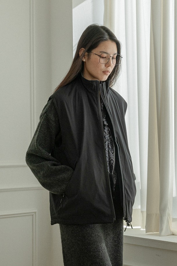 블랙 색상의 루즈핏 '집업' 베스트입니다. 부드러운 촉감의 폴리에스테르 소재로 제작되었으며, 봄, 가을 간절기에 착용하기 좋습니다. 민소매 디자인에 라운드넥으로 제작되었으며, 캐주얼하고 베이직한 스타일을 연출합니다. 얇은 두께감으로 편안하게 착용할 수 있으며, 지퍼 여밈 방식으로 간편하게 스타일링할 수 있습니다. 무지 디자인으로 다양한 룩에 활용하기 용이합니다.
