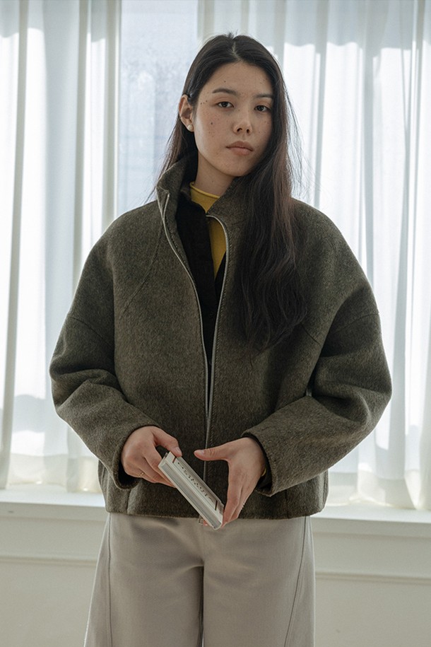 "지퍼 스탠드 칼라 숏 코트"는 여성 의류로, 가을과 겨울에 착용하기 좋습니다. 미니멀하고 베이직한 스타일로, 출근룩에 적합하며, 카키와 브라운 두 가지 색상으로 제공됩니다. 울 소재의 두꺼운 원단으로 제작되어 뻣뻣한 촉감을 주며, 긴 소매와 레귤러핏으로 디자인되었습니다. 심플한 디자인과 스탠드 칼라 디테일이 특징인 숏 기장의 집업 코트입니다.
