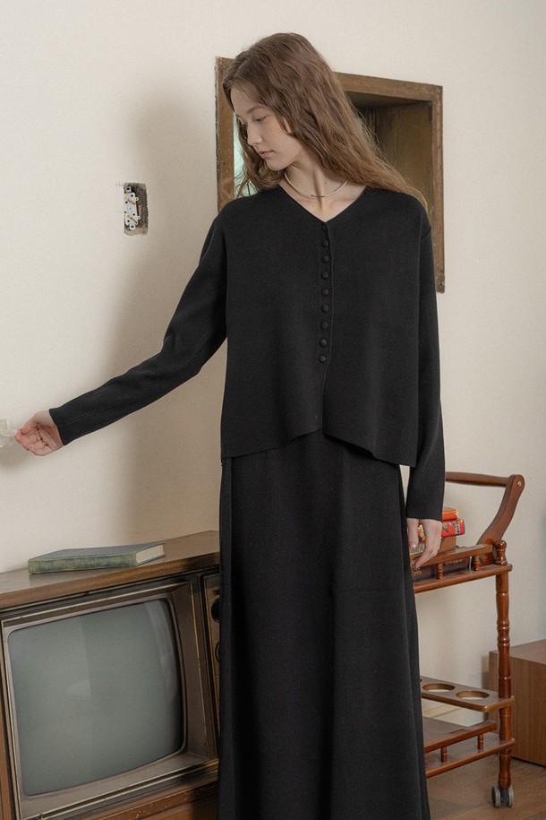 블랙 컬러의 브이넥 버튼 니트 탑 앤 스커트 세트입니다. 부드러운 니트 소재로 제작되어 겨울철에도 따뜻하게 착용할 수 있으며, 두꺼운 두께감으로 포근함을 더합니다. 긴 소매와 레귤러 핏으로 편안한 착용감을 선사하며, 미니멀하고 시크한 스타일을 연출합니다. 데이트룩, 모임룩 등 다양한 TPO에 활용 가능하며, 베이직한 디자인으로 유행을 타지 않고 오래도록 즐겨 입을 수 있습니다.
