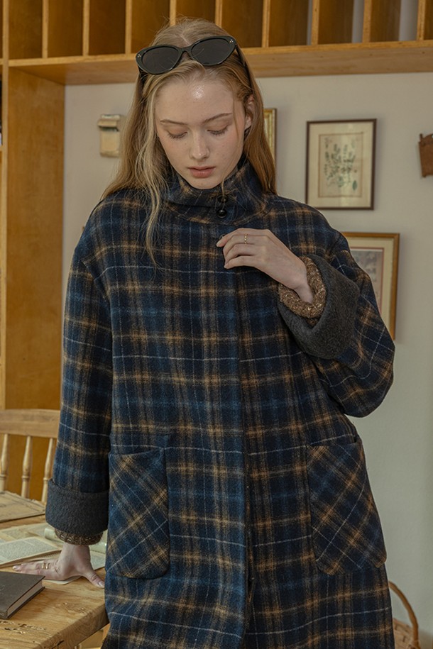 네이비 컬러의 윈터 체크 코트입니다. 울 소재로 제작되어 부드러운 촉감과 두꺼운 두께로 뛰어난 보온성을 제공합니다. 롱 기장의 루즈핏 싱글코트로, 클래식과 캐주얼 스타일 모두 소화 가능하며, 출근룩과 모임룩에 적합합니다. 체크 패턴이 돋보이며, 긴 소매와 버튼 여밈, 그리고 포켓 디테일이 특징입니다. 미니멀한 스타일 연출에도 용이합니다.
