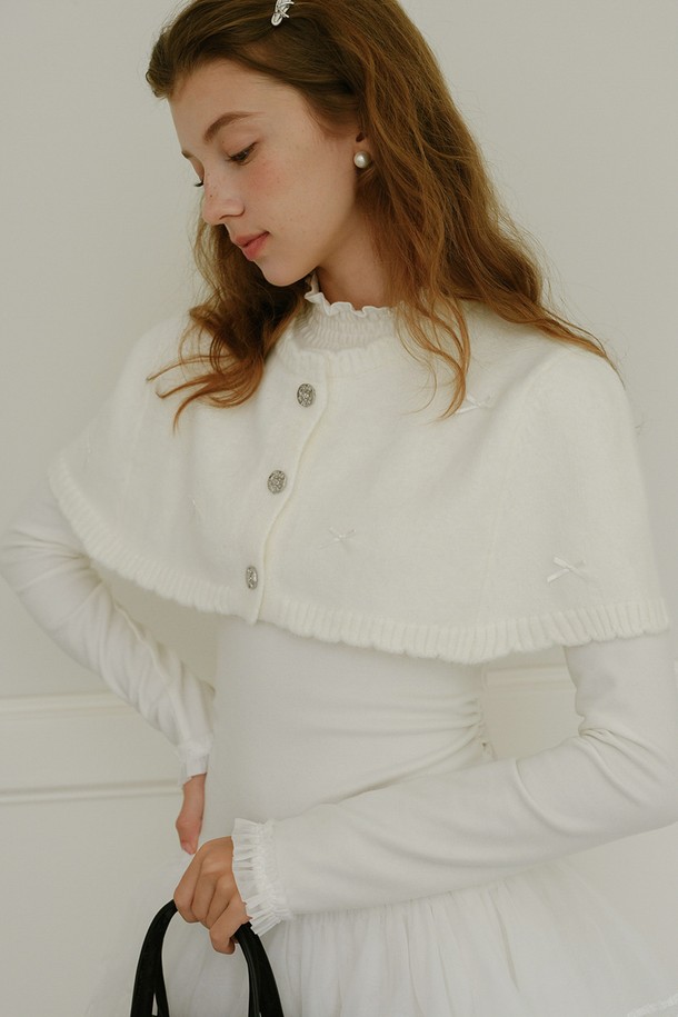 화이트 컬러의 보우 로즈 버튼 숄은 여성 고객을 위한 우아하고 로맨틱한 분위기를 연출하는 숄입니다. 니트 소재로 제작되어 부드러운 촉감과 뛰어난 보온성을 제공하며 가을, 겨울철에 따뜻하게 착용할 수 있습니다. 케이프 스타일과 숄 칼라 디자인에 리본과 버튼 디테일이 더해져 클래식하면서도 세련된 스타일을 완성합니다. 데이트룩, 모임룩, 연말 모임룩 등 특별한 날에 우아함을 더해주는 필수 아이템입니다. 
