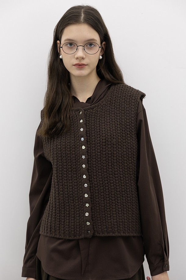 **그리드 니트 베스트_브라운**

부드러운 울 소재의 여성용 니트 베스트입니다. 가을, 겨울 시즌에 어울리는 두꺼운 두께감으로 따뜻하게 착용할 수 있습니다. 라운드넥과 레귤러핏 디자인에 클래식하고 베이직한 무드를 더했습니다. 그리드 패턴의 케이블 니트 짜임과 단추 디테일, 버튼업 스타일이 특징이며, 모임룩, 미니멀, 캐주얼 스타일 모두 소화 가능합니다. 민소매 기장으로 다양한 상의와 레이어드하여 연출하기 좋습니다.
