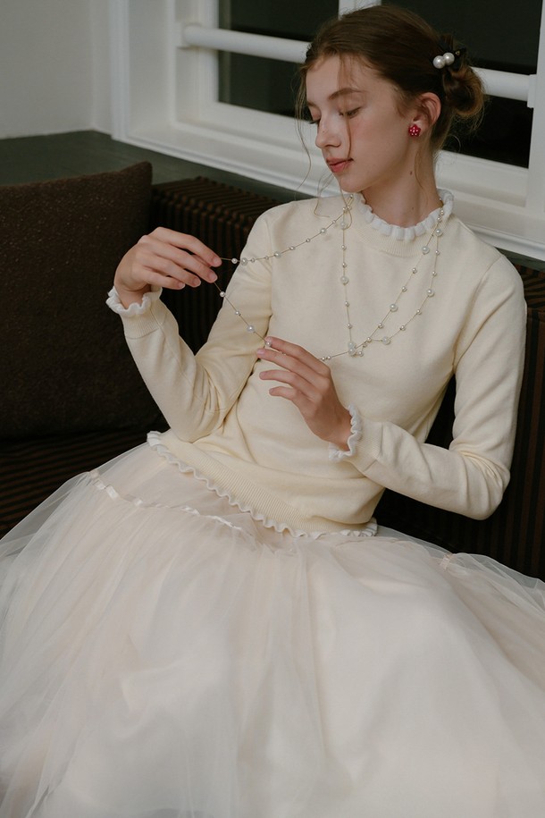 부드러운 러플 니트 탑_크림은 우아함과 클래식 무드를 동시에 선사하는 여성용 니트/스웨터입니다. 가을과 겨울 시즌에 적합하며, 레귤러 핏과 하프넥 디자인으로 포근함을 더했습니다. 두꺼운 두께감의 니트 소재와 부드러운 촉감이 편안한 착용감을 제공하며, 러플 디테일과 진주 장식이 포인트로 더해져 로맨틱한 분위기를 연출합니다. 데이트룩, 모임룩, 출근룩 등 다양한 TPO에 활용 가능하며, 클래식, 미니멀, 로맨틱 스타일을 즐기는 분들께 추천합니다. 긴 소매 기장과 크림 컬러는 어떤 하의와도 매치하기 용이합니다.
