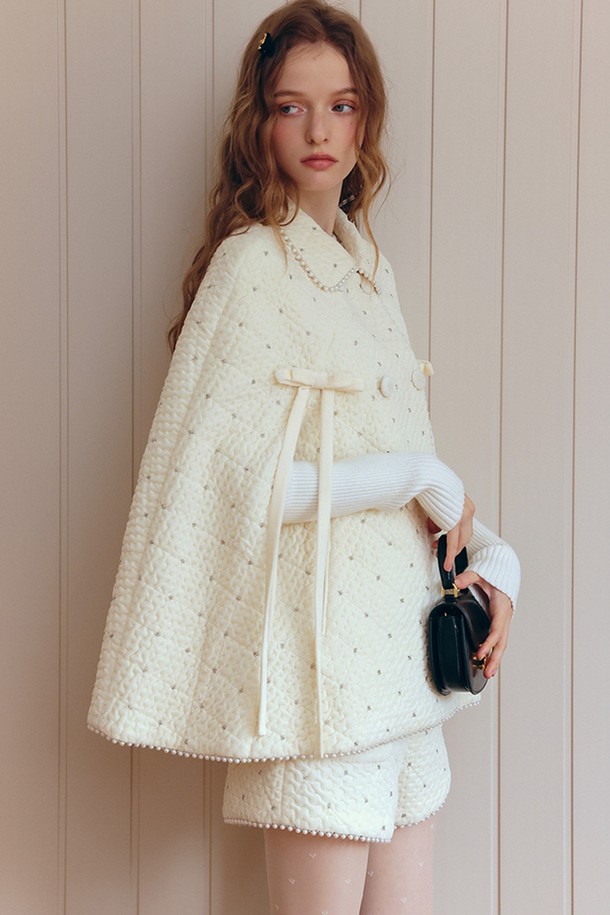 우아한 퀼팅 케이프 코트는 여성 고객을 위한 겨울 시즌 필수 아이템입니다. 아이보리, 화이트 컬러의 부드러운 울 소재로 제작되어 포근한 착용감을 선사하며, 넉넉한 루즈핏으로 편안하게 즐길 수 있습니다. 퀄팅 패턴과 리본 디테일이 더해져 엘레강스하고 우아한 무드를 연출하며, 데이트룩, 모임룩, 연말 모임룩 등 다양한 TPO에 활용 가능합니다. 클래식, 미니멀, 로맨틱 스타일을 즐겨 입는 분들께 추천하는 미디엄 기장의 케이프 코트입니다.
