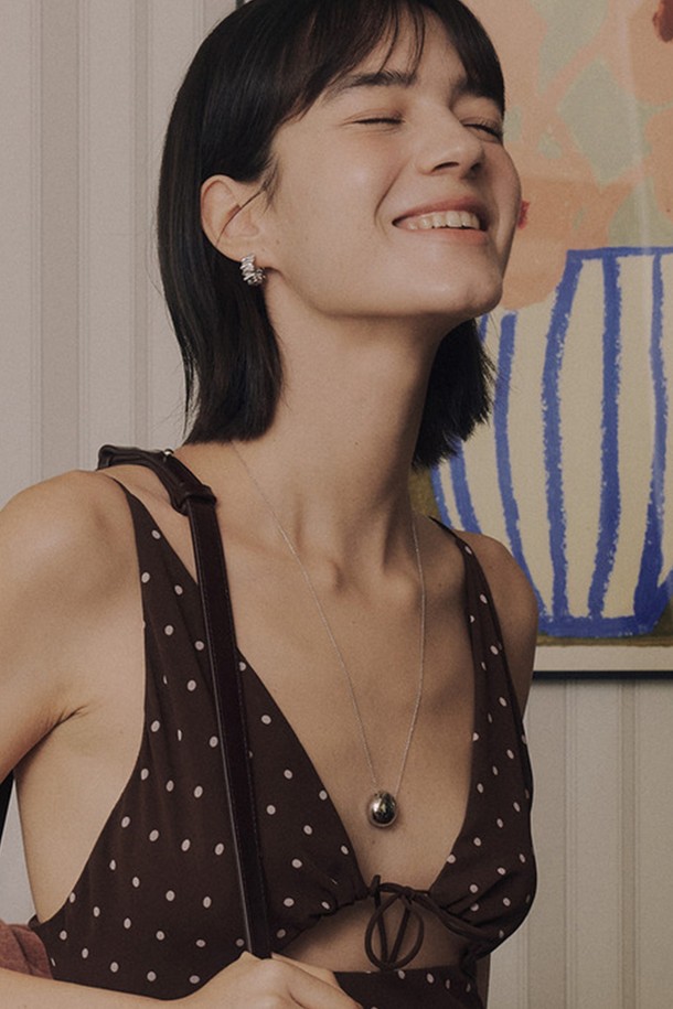 페블 펜던트 목걸이 [실버]는 미니멀하고 모던한 스타일을 추구하는 여성들을 위한 목걸이입니다. 볼륨감 있는 비정형 라운드 형태의 펜던트 디자인이 특징이며, 고광택 실버 컬러로 세련된 느낌을 더했습니다. 얇은 체인과 가벼운 무게감으로 편안한 착용감을 제공하며, 일상 및 데이트룩, 모임룩 등 다양한 TPO에 활용하기 좋습니다. 브라스 소재로 제작되어 은은한 광택을 자랑하며 시크하고 클래식한 무드를 연출합니다.
