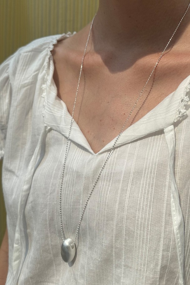 듀오브 목걸이는 미니멀하고 베이직한 스타일의 목걸이입니다. 물방울 모양 펜던트와 매트 피니시, 미니멀 디자인이 특징이며, 가볍게 착용하기 좋습니다. 브라스 소재로 제작되었으며, 실버 색상으로 데이트룩이나 카페룩에 잘 어울립니다. 체인 길이는 72+7cm(조절 가능)이며, 펜던트 크기는 15*28mm입니다. 6g의 가벼운 무게감으로 레이어드하여 데일리로 착용하기 좋습니다.
