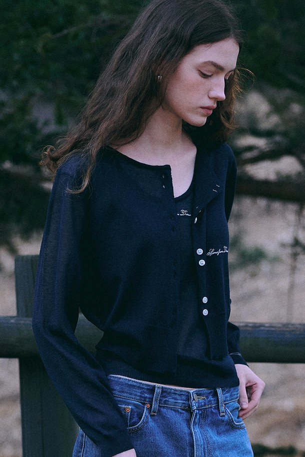 네이비 컬러의 여름 니트 재킷 + 슬리브입니다. 레이온, 린넨, 폴리에스테르 혼방 소재로 제작되어 부드러운 촉감과 하늘거리는 텍스쳐를 자랑합니다. 라운드넥 디자인에 릴렉스 핏으로 편안하게 착용 가능하며, 긴 소매 기장입니다. 시그니처 자수 디테일과 스냅 버튼 클로저가 특징이며, 여름, 간절기에 데이트룩, 카페룩, 캐주얼, 미니멀, 클래식 스타일을 연출하기 좋습니다. 얇은 두께감으로 통기성이 우수하며, 비침이 있을 수 있습니다.
