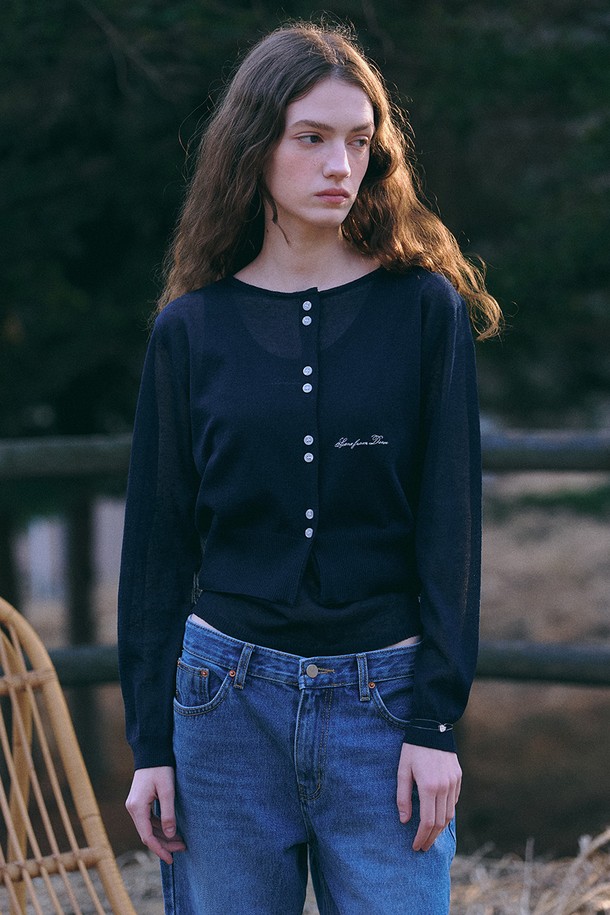 네이비 컬러의 여름 니트 재킷 + 슬리브입니다. 레이온, 린넨, 폴리에스테르 혼방 소재로 제작되어 부드러운 촉감과 하늘거리는 텍스쳐를 자랑합니다. 라운드넥 디자인에 릴렉스 핏으로 편안하게 착용 가능하며, 긴 소매 기장입니다. 시그니처 자수 디테일과 스냅 버튼 클로저가 특징이며, 여름, 간절기에 데이트룩, 카페룩, 캐주얼, 미니멀, 클래식 스타일을 연출하기 좋습니다. 얇은 두께감으로 통기성이 우수하며, 비침이 있을 수 있습니다.
