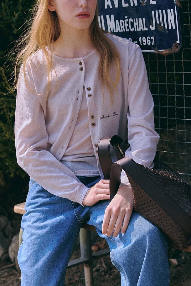 아이보리 컬러의 여름 니트 재킷 + 슬리브입니다. 미니멀하고 베이직한 스타일로, 봄, 여름에 착용하기 좋습니다. 릴랙스핏으로 편안하며, 라운드 넥과 긴소매 디자인이 특징입니다. 레이온, 린넨, 폴리에스테르 혼방 소재로 제작되어 부드러운 촉감과 통기성을 제공하며, 반투명 소재와 자수 로고 디테일이 돋보입니다. 스냅 버튼 여밈으로 간편하게 착용 가능하며, 데이트룩, 카페룩 등 다양한 TPO에 레이어드 스타일로 연출하기 좋습니다.
