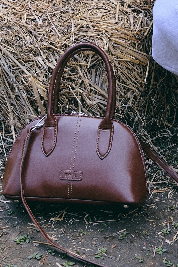 엘렌 시티 토트백 [글로시 체스넛 브라운]은 여성 고객을 위한 미디엄 사이즈의 토트백입니다. 인조 가죽 소재에 빈티지 무드를 더했으며, 돔 쉐이프 디자인과 곡선 실루엣이 특징입니다. 무지 패턴에 로고 패치와 스티치 디테일로 포인트를 주어 클래식하면서도 캐주얼한 스타일을 연출합니다. 탈부착 가능한 크로스 스트랩과 손잡이, 더블 지퍼, 태블릿/노트북 수납이 가능한 실용적인 가방입니다. 쇼핑룩이나 모임룩에 매치하여 세련된 스타일을 완성해보세요.
