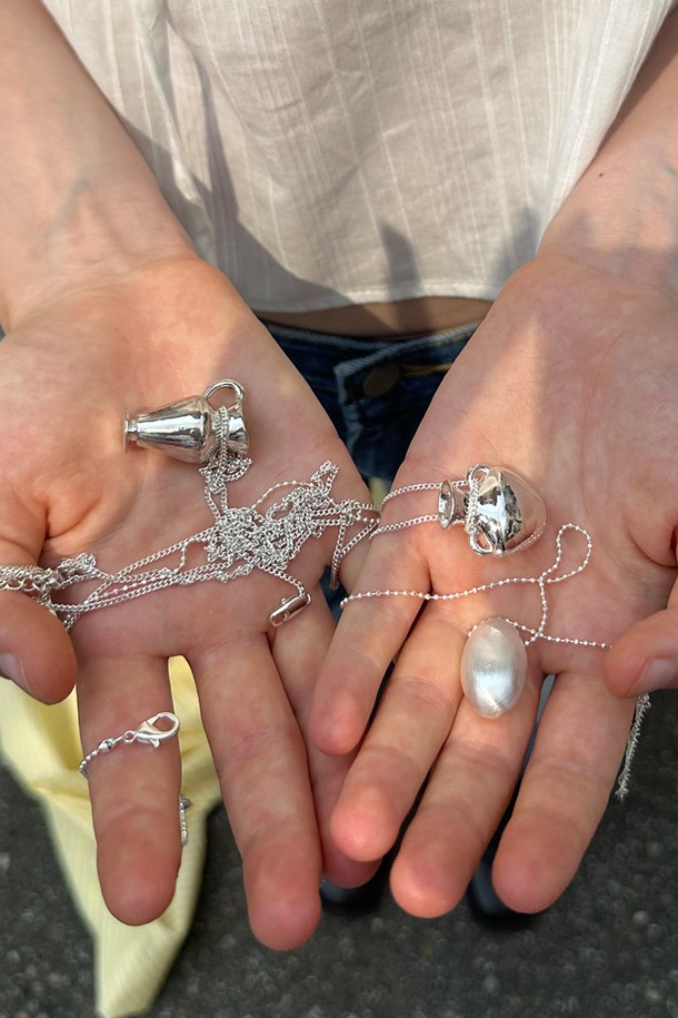 듀오브 목걸이는 미니멀하고 베이직한 스타일의 목걸이입니다. 물방울 모양 펜던트와 매트 피니시, 미니멀 디자인이 특징이며, 가볍게 착용하기 좋습니다. 브라스 소재로 제작되었으며, 실버 색상으로 데이트룩이나 카페룩에 잘 어울립니다. 체인 길이는 72+7cm(조절 가능)이며, 펜던트 크기는 15*28mm입니다. 6g의 가벼운 무게감으로 레이어드하여 데일리로 착용하기 좋습니다.
