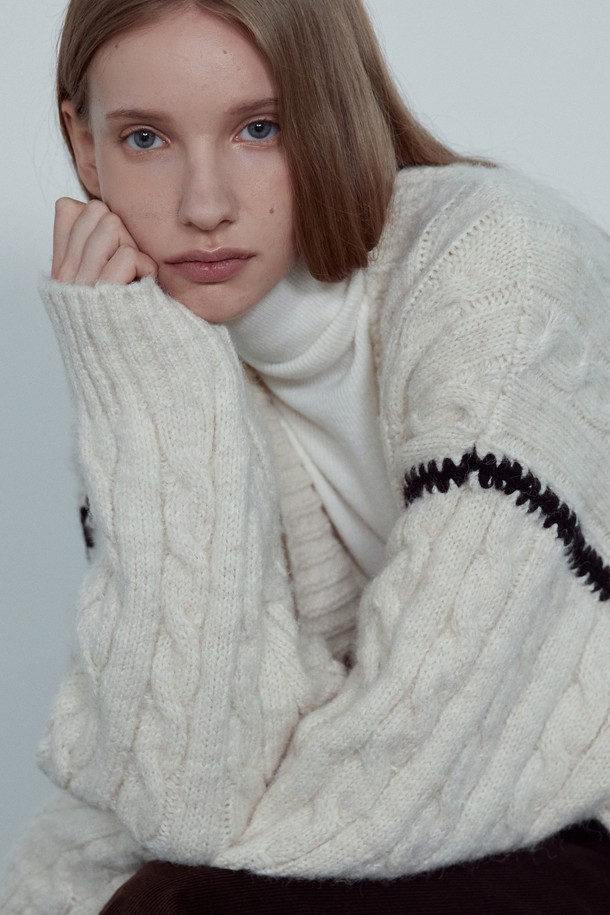 NOI (노이) COLORING LINE CABLE CARDIGAN_NFCA5266은 여성용 니트/스웨터 카테고리에 속하는 캐주얼 스타일의 가을/겨울용 긴소매 가디건입니다. 크림과 차콜 두 가지 색상으로 출시되었으며, 부드러운 촉감의 폴리에스테르, 나일론, 울, 스판덱스 혼방 소재로 제작되었습니다. 케이블 니트 패턴과 컬러 포인트 디테일이 돋보이며, 루즈핏으로 편안하게 착용 가능합니다. 코지하고 럭셔리한 분위기를 연출하여 겨울 데일리룩, 카페룩, 집콕룩 등 다양한 TPO에 활용하기 좋습니다. 클래식, 미니멀 스타일을 선호하는 분들께 추천합니다.
