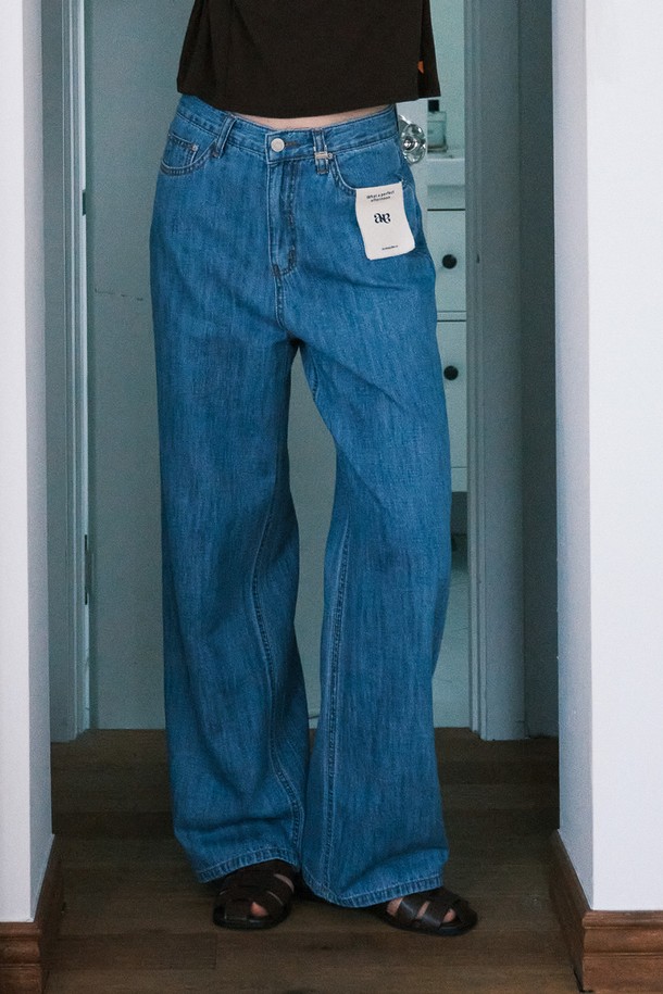 써머 클래식 데님 팬츠_NHDP5260은 여성용 데님 팬츠입니다. 딥블루와 라이트블루 두 가지 색상으로 제공되며, 여름철 일상에서 클래식하고 캐주얼한 스타일을 연출할 수 있습니다. 얇고 부드러운 면과 린넨 혼방 소재로 제작되어 편안한 착용감을 선사하며, 와이드 핏의 긴 기장으로 다리가 길어 보이는 효과를 줍니다. 로고가 각인된 벨트 루프와 탈부착 가능한 캔버스 패널 잠금장치, 면 라벨 디테일이 특징입니다. 데이트룩, 쇼핑룩 등 다양한 상황에 미니멀한 스타일로 활용하기 좋습니다.
