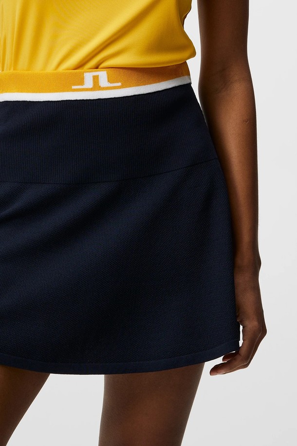 제이린드버그 SS 여성 골프 프리다 니트 스커트 네이비는 비스코스, 나일론, 폴리에스터, 엘라스틴 혼방 소재로 제작되어 봄, 여름 시즌에 적합한 여성 골프 스커트입니다. 스포티한 무드의 레귤러핏 미니 스커트로, 리브드 패턴과 네이비 컬러가 세련된 느낌을 더합니다. 신축성이 뛰어나 편안한 착용감을 제공하며, 대비되는 허리 밴드, JL 로고, 사이드 포켓, 내부 반바지, 이중 텍스처 디자인이 특징입니다. OEKO-TEX® 인증을 받은 이 스커트는 골프룩 또는 일상복으로 활용하기 좋습니다.
