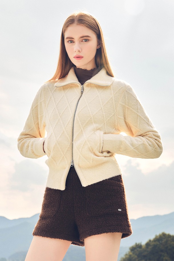 크림 컬러의 케이블 패턴이 돋보이는 여성용 방풍 집업 니트입니다. 가을, 겨울 시즌 골프 및 일상에서 캐주얼, 스포티하게 연출하기 좋습니다. 부드러운 촉감의 두꺼운 니트 소재로 제작되었으며, 크롭 기장과 레귤러핏으로 편안한 착용감을 선사합니다. 집업 스타일로 간편하게 여밀 수 있으며, 필드 위에서도 스타일리시함을 잃지 않도록 디자인되었습니다.
