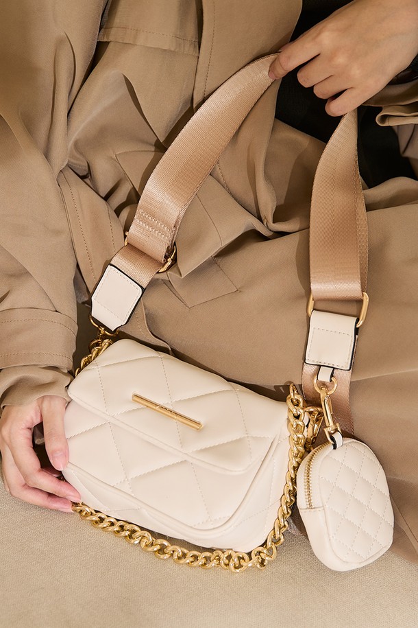 미니노리 크로스바디 백 - 화이트 ADB1H219HZ110은 여성스러운 스타일을 완성해 줄 미니 사이즈의 가방입니다. 부드러운 합성가죽 소재에 퀄팅 무늬가 더해져 고급스러운 분위기를 자아냅니다. 체인 디자인 장식과 골드 메탈 디테일이 세련된 포인트를 주며, 탈부착 가능한 스트랩으로 다양한 연출이 가능합니다. 데이트룩, 모임룩, 소개팅룩 등 여성스러운 스타일을 연출하고 싶은 날에 완벽하며, 사각 쉐입에 자석형 잠금 방식으로 편리하게 사용할 수 있습니다. 또한 동전 지갑이 포함되어 실용성까지 갖춘 아이템입니다.
