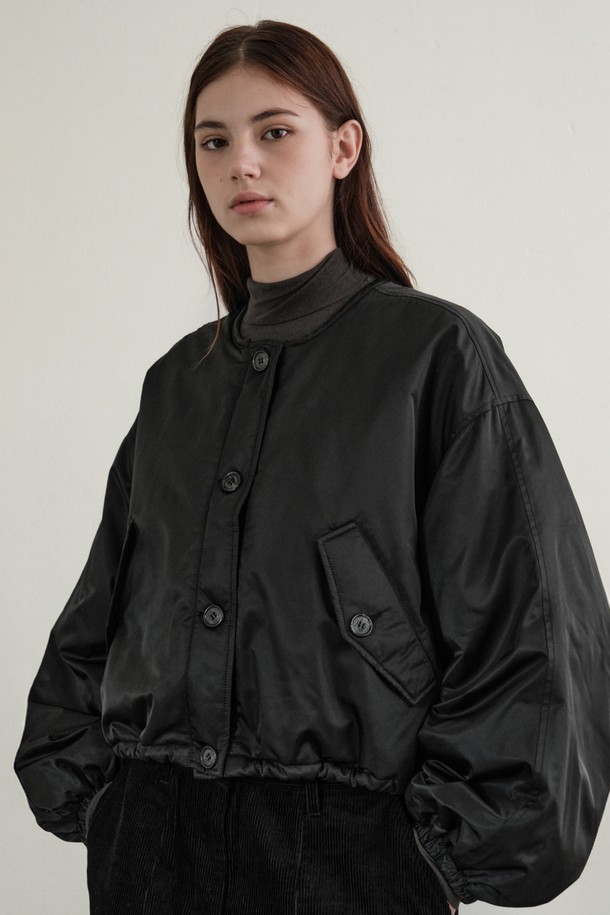 **여성 플리츠 리버서블 패딩 (블랙)**

미니멀하고 모던한 스타일의 여성용 플리츠 리버서블 패딩입니다. 겨울철 데일리룩에 적합하며, 양면 착용이 가능하여 다양한 스타일을 연출할 수 있습니다. 부드러운 촉감의 폴리에스테르와 나일론 혼방 소재로 제작되었으며, 3M 씬슐레이트 충전재를 사용하여 보온성과 경량성을 높였습니다. 오버핏 크롭 기장으로 트렌디함을 더했으며, 웨이브 퀄팅 패턴과 벌룬 소매 디자인이 특징입니다. 버튼 여밈 방식과 블랙 컬러로 심플하면서도 세련된 겨울 스타일을 완성해보세요.
