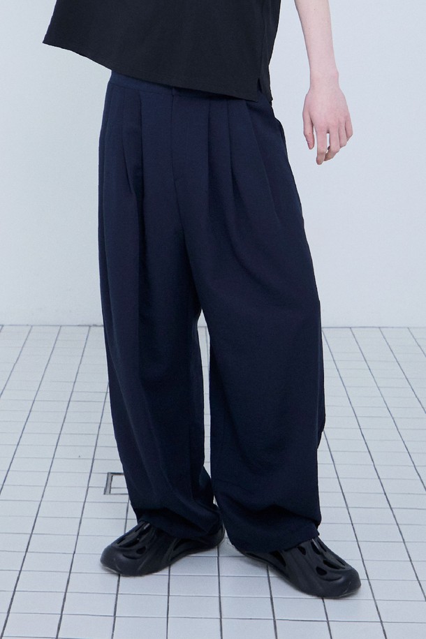 네이비 컬러의 드래프트 스트링 와이드 팬츠입니다. 여름철 시원하게 착용하기 좋은 얇은 두께감의 루즈핏 와이드 팬츠로, 레이온, 폴리에스테르, 나일론 혼방 소재로 제작되어 부드러운 촉감을 선사합니다. 허리 밴딩과 밑단 스트링 디테일이 편안한 착용감을 제공하며, 다트 디테일로 입체적인 실루엣을 완성합니다. 구김이 적고 통기성이 좋아, 동네 마실룩, 여행룩, 캐주얼, 미니멀, 클래식 스타일 등 다양한 스타일에 활용하기 좋습니다.
