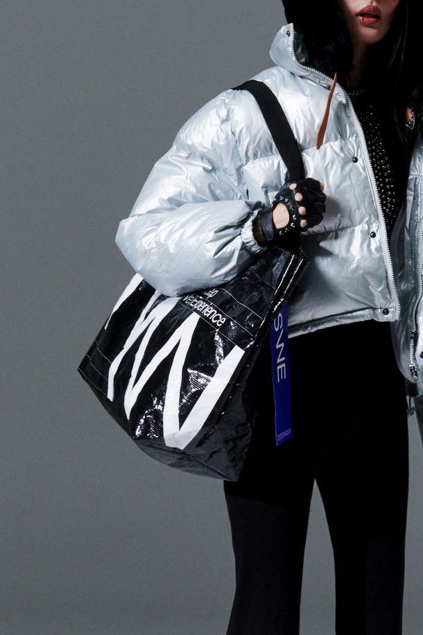 NSWE(엔에스더블유이) REUSABLE BAG - NSWBAGBK는 남성을 위한 미디엄 사이즈의 블랙 에코백입니다. 주름 패턴과 로고 디자인 장식이 돋보이며, PVC와 폴리에스테르 소재를 사용하여 방수 및 생활 방수 기능을 갖췄습니다. 내부 포켓과 대용량 수납이 가능하며, 이중 코팅과 광택 마감으로 고급스러움을 더했습니다. 오픈형 잠금 방식의 사각 디자인으로, 여행룩, 캠핑룩, 쇼핑룩 등 다양한 TPO에 미니멀, 캐주얼, 시티보이 스타일로 활용하기 좋습니다.
