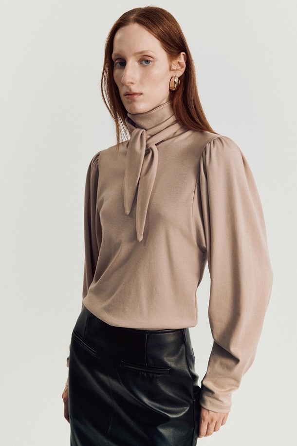 린지 타이 티셔츠 _ 베이지는 여성스러운 무드를 연출하는 슬림핏 긴소매 티셔츠입니다. 부드러운 면과 텐셀 혼방 소재로 제작되어 편안한 착용감을 선사하며, 하이넥 또는 리본 타이로 연출 가능한 넥 라인이 특징입니다. 은은한 베이지 컬러에 퍼프 숄더와 리본 타이 디테일이 더해져 우아하고 미니멀한 스타일을 완성합니다. 데이트룩, 모임룩, 카페룩 등 다양한 TPO에 활용 가능하며, 클래식, 미니멀, 로맨틱 스타일을 즐기는 분들께 추천합니다.
