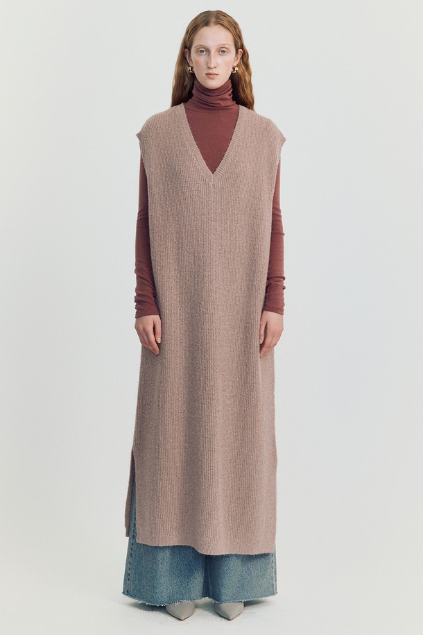 볼로디나 니트 롱 베스트 _ 핑크는 여성스러운 분위기를 연출하는 롱 기장의 니트 베스트입니다. 부드러운 촉감의 아크릴, 폴리에스테르, 나일론, 울 혼방 소재로 제작되었으며, 가을, 겨울 시즌에 착용하기 좋습니다. 헤어리 하치 니트 패턴과 미니멀 스티치 디테일이 돋보이며, 루즈핏과 브이넥 디자인으로 편안하게 착용할 수 있습니다. 사이드 슬릿과 드롭숄더 디테일이 특징이며, 베스트 또는 드레스로 활용 가능하여 다양한 스타일을 연출할 수 있습니다. 핑크, 아이보리, 브라운, 블랙 네 가지 색상으로 출시되었습니다.
