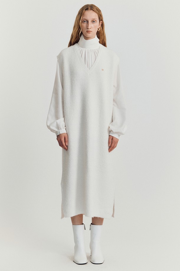 볼로디나 니트 롱 베스트 _ 아이보리 (Volodina Knit Long Vest _ Ivory)는 가을, 겨울에 착용하기 좋은 여성용 베스트입니다. 미니멀하고 베이직한 스타일로, 데이트룩과 겨울 데일리룩에 활용하기 좋습니다. 부드러운 촉감의 아크릴, 폴리에스테르, 나일론, 울 혼방 소재로 제작되었으며, 얇은 두께감과 롱 기장으로 다양한 스타일 연출이 가능합니다. 브이넥 디자인에 민소매이며, 루즈핏으로 편안하게 착용할 수 있습니다. 사이드 슬릿과 드롭 숄더 디테일, 미니멀 스티치가 특징이며, 드레스 또는 베스트로 활용할 수 있습니다.
