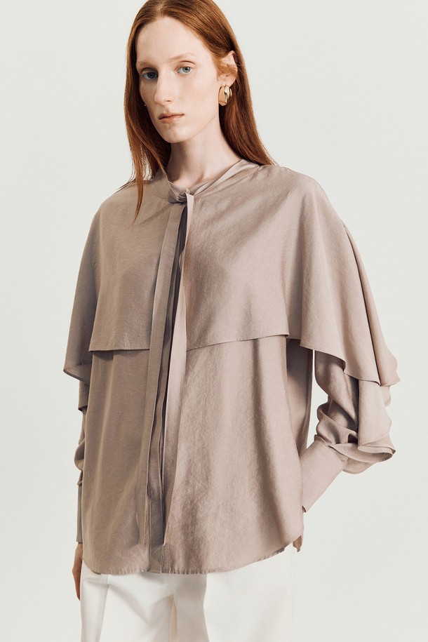 나디 케이프 블라우스 (Pink)는 여성스러운 무드를 연출하는 블라우스입니다. 부드러운 레이온과 폴리에스테르 혼방 소재로 제작되어 봄, 여름에 시원하게 착용하기 좋습니다. 라운드넥에 케이프 디자인과 타이 디테일, 티어드 슬리브가 더해져 우아하고 로맨틱한 스타일을 완성합니다. 루즈핏으로 편안하며, 핑크와 브라운 두 가지 색상으로 출시되어 데이트룩, 카페룩, 모임룩 등 다양한 TPO에 활용할 수 있습니다. 클래식하고 미니멀한 스타일을 선호하는 분들께 추천합니다.
