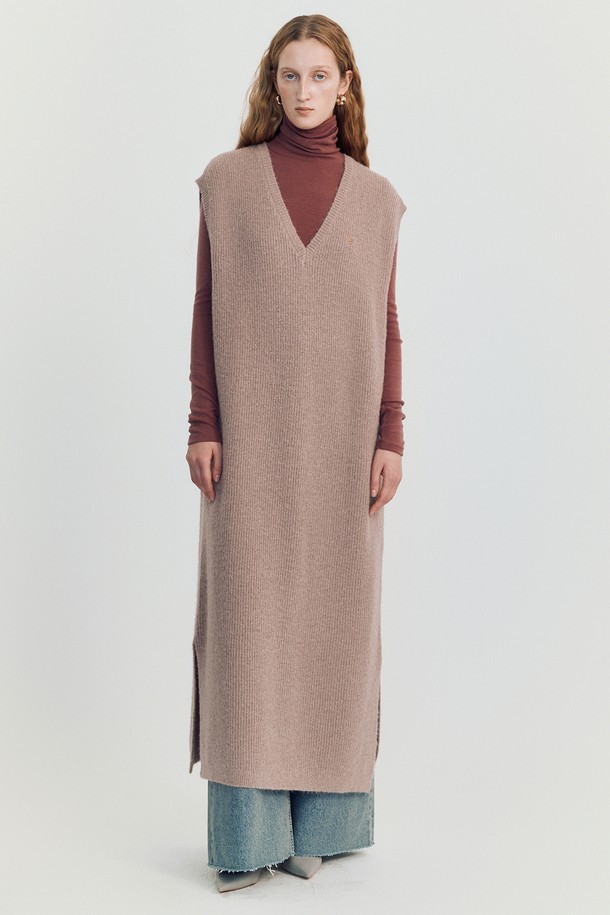 볼로디나 니트 롱 베스트 _ 핑크는 여성스러운 분위기를 연출하는 롱 기장의 니트 베스트입니다. 부드러운 촉감의 아크릴, 폴리에스테르, 나일론, 울 혼방 소재로 제작되었으며, 가을, 겨울 시즌에 착용하기 좋습니다. 헤어리 하치 니트 패턴과 미니멀 스티치 디테일이 돋보이며, 루즈핏과 브이넥 디자인으로 편안하게 착용할 수 있습니다. 사이드 슬릿과 드롭숄더 디테일이 특징이며, 베스트 또는 드레스로 활용 가능하여 다양한 스타일을 연출할 수 있습니다. 핑크, 아이보리, 브라운, 블랙 네 가지 색상으로 출시되었습니다.
