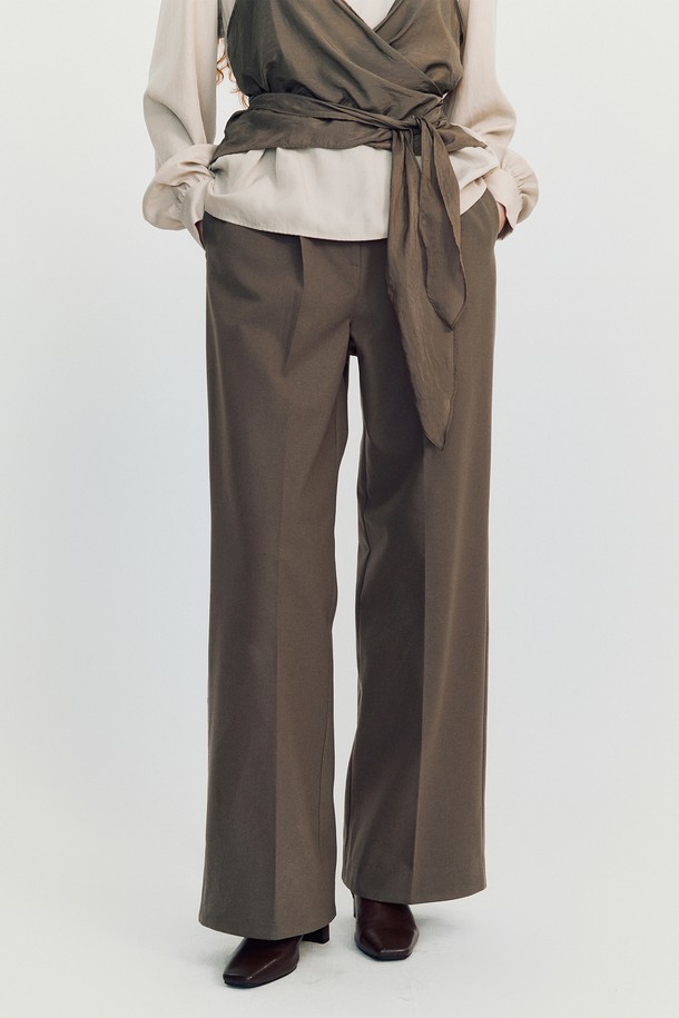 핏 울 슬랙스 _ 브라운은 클래식하면서도 미니멀한 무드를 연출하는 여성용 슬랙스입니다. 부드러운 촉감의 두꺼운 폴리에스테르 소재로 제작되어 겨울철에도 따뜻하게 착용할 수 있습니다. 하이웨스트 디자인과 앞면 플리츠 디테일이 다리 라인을 더욱 길어 보이게 하며, 루즈핏 와이드 레그로 편안한 착용감을 선사합니다. 뒷면 히든 밴딩과 장식용 버클 디테일로 실용성과 스타일을 모두 잡았습니다. 오피스룩, 겨울 데일리룩, 모임룩 등 다양한 TPO에 활용할 수 있는 머스트 해브 아이템입니다.
