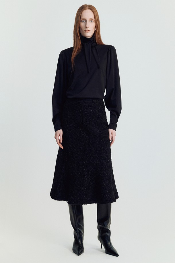 솔린 트위드 스커트 _ 블랙은 겨울철 여성들을 위한 클래식하고 엘레강스한 스타일의 트위드 스커트입니다. 블랙과 아이보리 두 가지 색상으로 출시되었으며, 오피스, 포멀, 데일리룩 등 다양한 TPO에 활용할 수 있습니다. 울과 폴리에스테르 혼방 소재로 제작되어 부드러운 촉감과 두꺼운 두께감을 자랑하며, A라인 플레어 핏이 여성스러운 실루엣을 연출합니다. 정전기 방지 안감과 허리 미끄럼 방지 테이프, 무릎 아래 기장으로 편안함과 실용성을 더했습니다. 시크하고 미니멀한 스타일을 선호하는 분들께 추천합니다.
