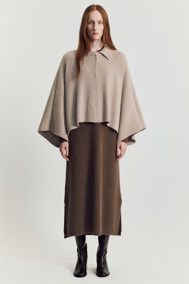 로디 케이프 니트 재킷_ 베이지는 울과 나일론 혼방 소재의 여성용 케이프입니다. 부드러운 촉감과 두꺼운 두께로 가을, 겨울에 따뜻하게 착용할 수 있으며, 하이 울 함량으로 고급스러운 분위기를 더합니다. 베이지, 아이보리, 브라운, 블랙 등 다양한 색상으로 출시되었으며, 루즈핏 디자인과 톤온톤 배색으로 우아하고 미니멀한 스타일을 연출합니다. 어깨를 자연스럽게 감싸는 테이프 형태의 실루엣으로 코트나 카디건 위에 레이어드하여 활용할 수 있습니다. 데일리룩, 모임룩, 데이트룩 등 다양한 TPO에 클래식, 미니멀, 시크한 스타일을 더해보세요.
