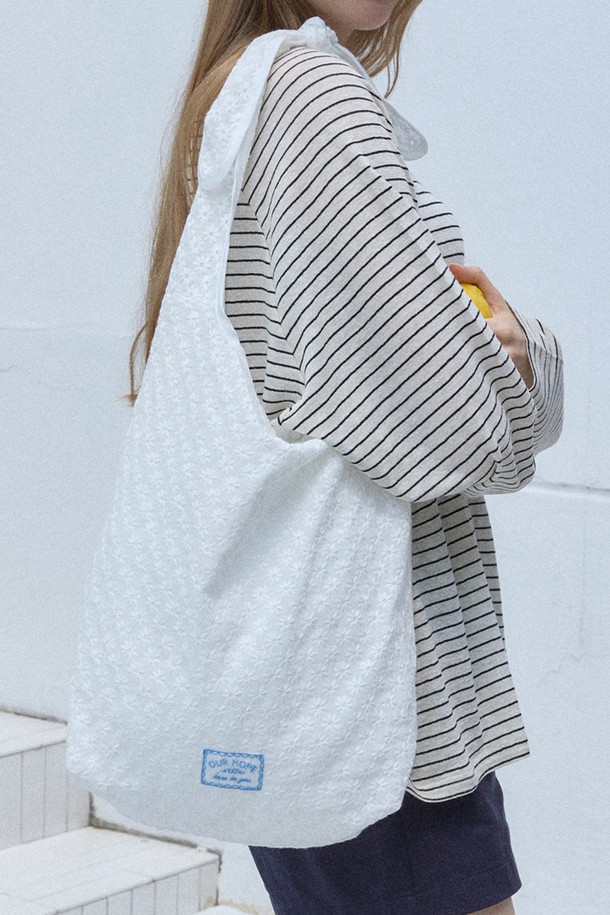 마가렛 자수 리본 백 - 아이보리는 여성스러운 스타일을 완성하는 미디엄 사이즈의 에코백입니다. 부드러운 면 소재에 섬세한 플라워 자수와 레이스, 리본 디테일이 사랑스러운 분위기를 더합니다. 가볍고 실용적인 디자인으로 일상, 쇼핑, 여행 등 다양한 TPO에 활용하기 좋습니다. 넉넉한 수납공간과 내부 포켓은 실용성을 높여줍니다. 아이보리 컬러의 사각 형태 백으로 걸리시, 로맨틱, 캐주얼 룩에 매치하여 여성스러운 스타일을 연출해보세요.
