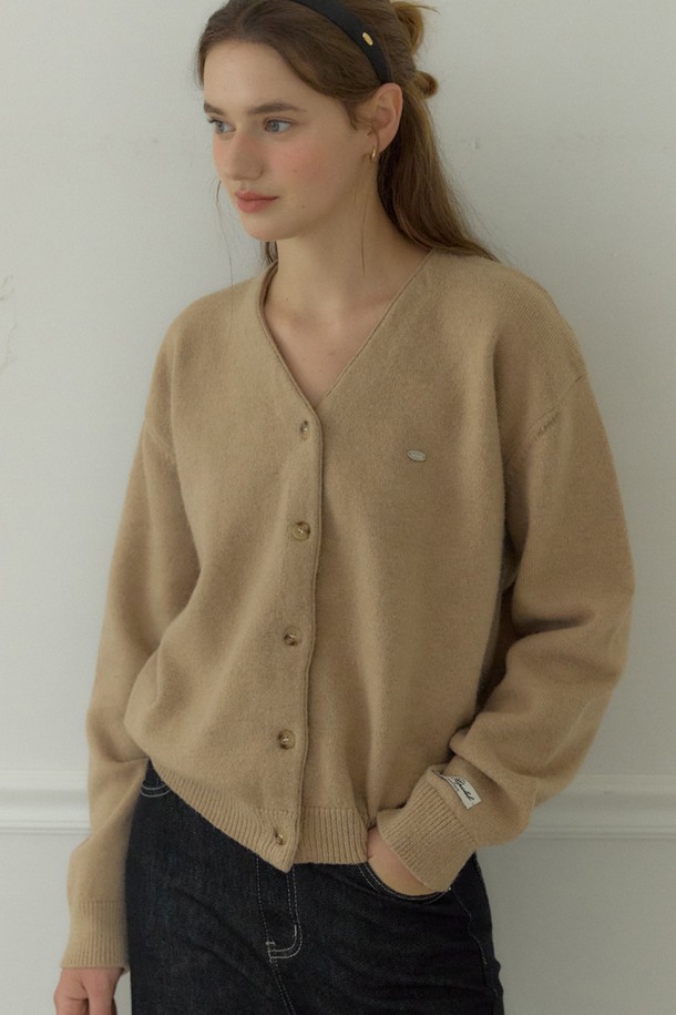 베이지 컬러의 Logo V-neck 코지 가디건은 여성스러운 실루엣을 연출하는 니트/스웨터입니다. 부드러운 울, 나일론, 폴리에스터 혼방 소재로 제작되어 따뜻하고 포근한 착용감을 선사합니다. 브이넥 디자인과 루즈핏으로 편안함을 더하며, 긴 소매와 중간 두께감으로 봄, 가을, 겨울철 데일리룩에 활용하기 좋습니다. 이중 손바느질 마감과 시그니처 장식 디테일, 소매단과 밑단의 립조직이 돋보이며, 'Fall '25 Poetry & Plaid Collection' 제품으로 클래식, 미니멀, 프레피 스타일을 즐기는 분들께 추천합니다. 카페룩, 겨울 데일리룩에 매치하여 스타일리시하게 연출해보세요.
