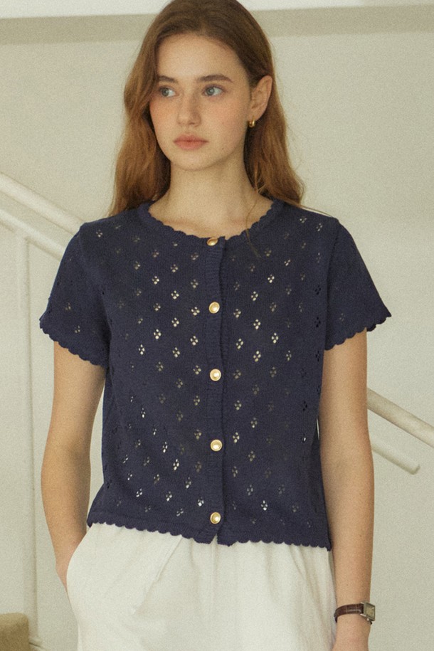 골디쉬 버튼 펀칭 가디건 - 네이비는 여성스러운 무드를 연출하는 봄 시즌 필수 아이템입니다. 부드러운 아크릴 소재와 얇은 두께감으로 편안한 착용감을 선사하며, 라운드넥과 레귤러핏 디자인으로 단정하면서도 여성스러운 실루엣을 완성합니다. 네이비, 아이보리, 레드의 세련된 컬러 팔레트로 다양한 스타일을 연출할 수 있으며, 펀칭 레이스 패턴과 스캘럽 엣지 디테일이 로맨틱한 분위기를 더합니다. 18K 골드 도금 버튼과 골드 로고 디테일이 고급스러움을 더하며, 형태 유지력과 필링 방지 기능으로 오랜 기간 변함없이 착용할 수 있습니다. 데이트룩, 카페룩과 같은 특별한 날이나 데일리룩으로 활용하여 클래식하면서도 사랑스러운 분위기를 연출해 보세요.
