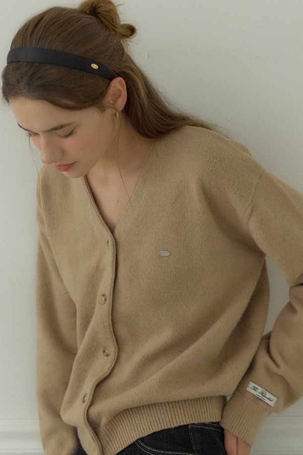 베이지 컬러의 Logo V-neck 코지 가디건은 여성스러운 실루엣을 연출하는 니트/스웨터입니다. 부드러운 울, 나일론, 폴리에스터 혼방 소재로 제작되어 따뜻하고 포근한 착용감을 선사합니다. 브이넥 디자인과 루즈핏으로 편안함을 더하며, 긴 소매와 중간 두께감으로 봄, 가을, 겨울철 데일리룩에 활용하기 좋습니다. 이중 손바느질 마감과 시그니처 장식 디테일, 소매단과 밑단의 립조직이 돋보이며, 'Fall '25 Poetry & Plaid Collection' 제품으로 클래식, 미니멀, 프레피 스타일을 즐기는 분들께 추천합니다. 카페룩, 겨울 데일리룩에 매치하여 스타일리시하게 연출해보세요.
