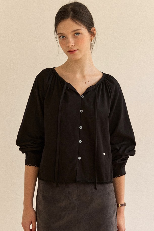 블랙 색상의 피치드 리본 셔링 블라우스입니다. 부드러운 면 소재로 제작되어 봄, 여름 시즌에 시원하게 착용하기 좋습니다. 브이넥 라인에 셔링과 리본 디테일이 더해져 페미닌한 무드를 연출합니다. 레귤러 핏과 반소매 기장으로 편안하게 착용 가능하며, 데이트룩, 모임룩, 클래식, 미니멀 스타일 모두 소화할 수 있습니다. 단추 디테일이 있어 포인트를 더했습니다.

