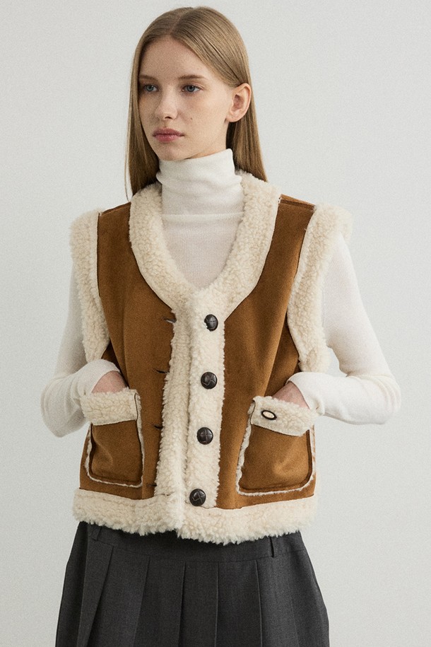 리버시블 쉐어링 무스탕 베스트 - 카멜은 부드러운 양털과 스웨이드 소재로 제작되어 따뜻하고 포근한 착용감을 선사합니다. 가을과 겨울, 두 계절 모두 활용 가능하며 캐주얼, 클래식 등 다양한 스타일을 연출할 수 있습니다. 무지 디자인에 크롭 기장, 민소매 디자인으로 세련된 느낌을 더했습니다. 단추 여밈 방식과 레귤러핏으로 편안하게 착용 가능하며, 리버시블 디자인과 포켓 디테일이 실용성을 높여줍니다. 아이보리 색상도 함께 출시되어 취향에 맞게 선택할 수 있습니다.
