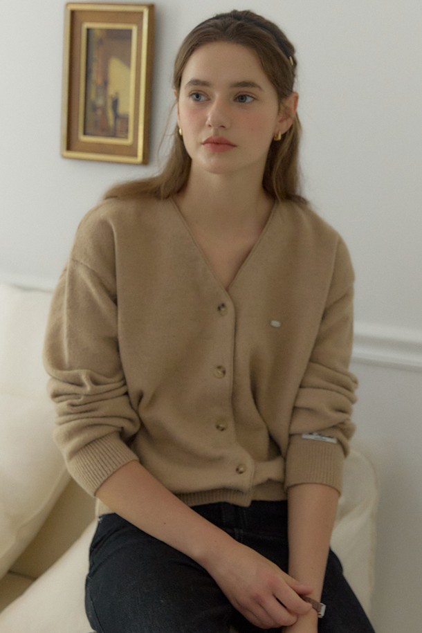 베이지 컬러의 Logo V-neck 코지 가디건은 여성스러운 실루엣을 연출하는 니트/스웨터입니다. 부드러운 울, 나일론, 폴리에스터 혼방 소재로 제작되어 따뜻하고 포근한 착용감을 선사합니다. 브이넥 디자인과 루즈핏으로 편안함을 더하며, 긴 소매와 중간 두께감으로 봄, 가을, 겨울철 데일리룩에 활용하기 좋습니다. 이중 손바느질 마감과 시그니처 장식 디테일, 소매단과 밑단의 립조직이 돋보이며, 'Fall '25 Poetry & Plaid Collection' 제품으로 클래식, 미니멀, 프레피 스타일을 즐기는 분들께 추천합니다. 카페룩, 겨울 데일리룩에 매치하여 스타일리시하게 연출해보세요.
