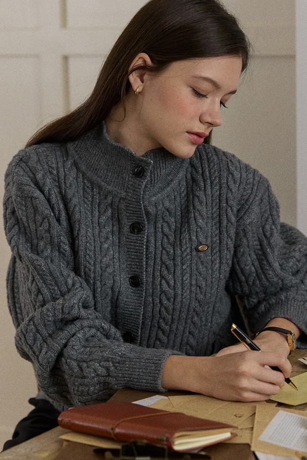 세련된 분위기를 연출하는 '캐롤라인 울 하이넥 버튼 가디건 - 그레이'입니다. 부드러운 울 소재와 두꺼운 두께감으로 가을, 겨울 시즌 따뜻하게 착용할 수 있습니다. 클래식하고 베이직한 디자인에 하이넥, 크롭 기장, 케이블 니트 패턴이 더해져 여성스러운 무드를 선사하며, 버튼업 디자인으로 포인트를 더했습니다. 데이트룩, 모임룩, 그리고 미니멀, 캐주얼 스타일 모두 소화 가능한 활용도 높은 아이템입니다.
