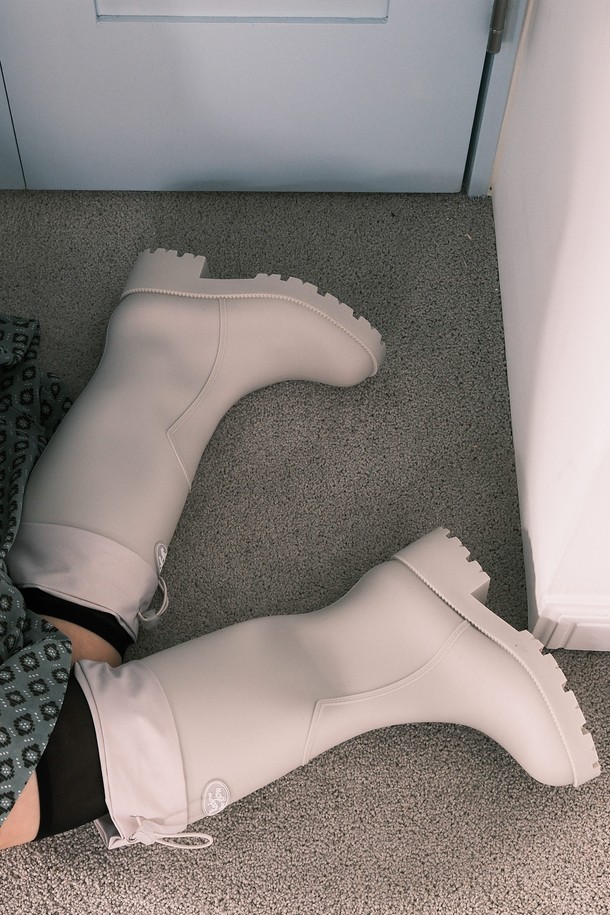 HOU LONG 레인 부츠 5 컬러는 여성용 레인부츠로, 일상생활과 우천 시 모두 활용 가능합니다. 블랙, 브라운, 그레이, 아이보리, 레몬 5가지 다채로운 컬러로 출시되어, 여행룩, 캐주얼, 미니멀, 클래식 등 다양한 스타일을 연출할 수 있습니다. 5cm 청키힐과 롱부츠 디자인으로 다리 라인을 더욱 돋보이게 하며, PVC 소재에 원형 로고 디테일, 미끄럼 방지 밑창, 넓은 밑창 설계, 상단 스트랩 디자인으로 기능성과 스타일을 모두 갖췄습니다. 먼지백과 패키지 박스도 함께 제공됩니다.
