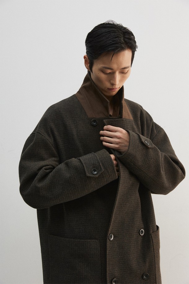 올리브와 오렌지 컬러의 맥시 체크 코트입니다. 울과 폴리에스터 혼방 소재로 제작되어 부드러운 촉감과 두꺼운 두께감을 자랑하며, 가을과 겨울에 따뜻하게 착용할 수 있습니다. 더블 버튼, 오버핏 디자인으로 클래식하면서도 모던한 스타일을 연출하며, 헤링본 체크 패턴이 세련된 느낌을 더합니다. 스탠드업 칼라, 너트 단추, 스웨이드 터치 배색 디테일이 돋보이는 더블 코트로, 출근룩, 모임룩, 데이트룩 등 다양한 TPO에 활용 가능하며, 미니멀, 시크 스타일을 즐기는 남성분들께 추천합니다. 안감은 폴리에스터와 큐프라로 마감되었습니다.
