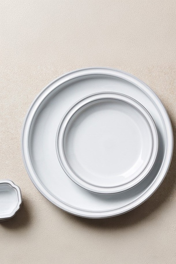 **콩트 원형접시(M) 1P**는 모던하고 시크한 디자인의 모노톤 원형 접시입니다. 도자기 소재로 제작되었으며, 화이트와 그레이 두 가지 색상으로 만나볼 수 있습니다. 점박이 무늬가 돋보이며, 전자레인지 및 식기세척기 사용이 가능하여 실용적입니다. 열충격강도 120도로 내구성을 높였으며, 24K 골드 인증을 거쳐 고급스러움을 더했습니다. 수작업 시유와 담금 방식으로 제작되어 자연스러운 유약 흐름, 바닥면 미세 얼룩, 표면의 작은 점/자국, 소성 중 나타나는 부분 자국 등의 특징을 가집니다.
