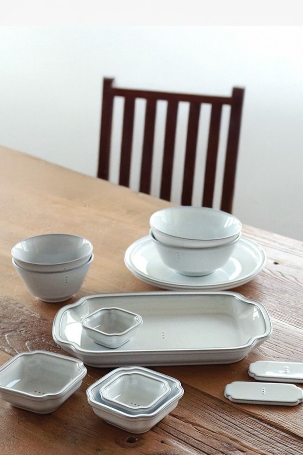 콩트 다이닝 식기세트 12p (2인조)는 모던하고 시크한 스타일을 추구하는 분들을 위한 도자기 식기 세트입니다. 화이트와 그레이 두 가지 색상으로 출시되었으며, 은은한 점박이 무늬가 특징입니다. 2인 가구를 위해 라이스볼 2p, 시리얼볼 2p, 직사각 접시 1p, 원형 접시 1p, 사각 소스볼(S) 2p, 사각 소스볼(M) 2p, 수저받침 2p로 구성되어 있습니다. 자연스러운 유약 흐름, 검은 흙빛, 수작업 시유 기법이 돋보이며 전자레인지 사용이 가능합니다. 제품별 색상 톤과 유약 농담 차이는 수작업의 특성을 보여줍니다.
