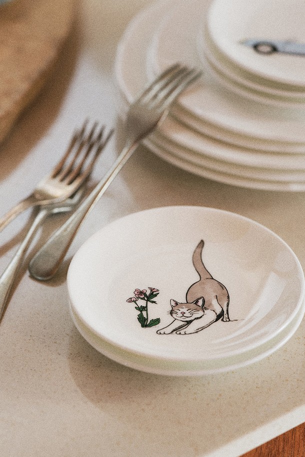 [한국도자기X티보에렘] 34. 5인치 접시 12.6CM 1P (스트레칭 캣)은 섬세한 고양이 캐릭터가 돋보이는 접시입니다. 얇고 가벼운 Fine Bone China 소재로 제작되어 뛰어난 내구성과 열보존성을 자랑하며, 투명한 유백색이 고급스러운 분위기를 더합니다. 아날로그 방식으로 그려진 건축물과 오브제 일러스트가 전사 프린팅 공법으로 표현되어 소장 가치를 높입니다. 전자레인지, 식기세척기 사용이 가능하며, KS 제품 인증, 납/카드뮴 용출시험, 잉크침투도 시험, 열충격 저항성 시험 등 엄격한 품질 검사를 통과하여 안심하고 사용할 수 있습니다.
