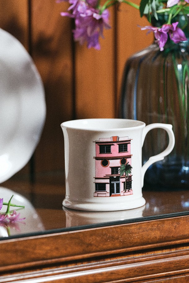 [한국도자기X티보에렘] 01. 머그 1P (마이애미)는 본차이나 소재로 제작되어 얇고 가벼우면서도 우수한 내구성과 보온성을 자랑합니다. 티보에렘 일러스트레이터와의 콜라보레이션을 통해 화이트와 핑크 컬러 바탕에 건축물 일러스트가 24K 골드 장식과 함께 프린트되어 소장 가치를 높입니다. 350ml 용량으로 전자레인지 및 식기세척기 사용이 가능하며, 반투명한 유백색과 낮은 수분 흡수율을 특징으로 합니다. KS 제품인증, 납/카드뮴 불검출 시험, 잉크침투저항성 및 내열충격성 시험, 24K 골드 인증을 완료하여 안심하고 사용할 수 있습니다. 일상생활에서 편안하게 사용할 수 있는 디자인의 머그컵입니다.

