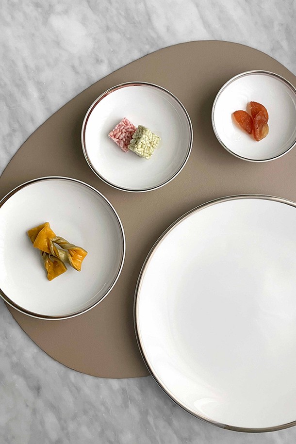 [트위그 뉴욕] 플래티늄 엣지 다과세트는 우아하고 클래식한 분위기를 연출하는 식기 세트입니다. 고밀도 본애쉬 소재를 사용하여 경량성과 보온성을 높였으며, 수작업으로 플래티늄 엣지 장식을 더해 고급스러움을 더했습니다. 구성은 10인치 접시 1개, 찬기 대/중/소 각 1개로 이루어져 다양한 다과를 즐기기에 적합합니다. 심플한 무지 디자인에 플래티늄 컬러와 화이트 컬러가 조화롭게 어우러져 테이블 세팅의 품격을 높여줍니다. 전자레인지, 식기세척기, 오븐 사용은 불가합니다.
