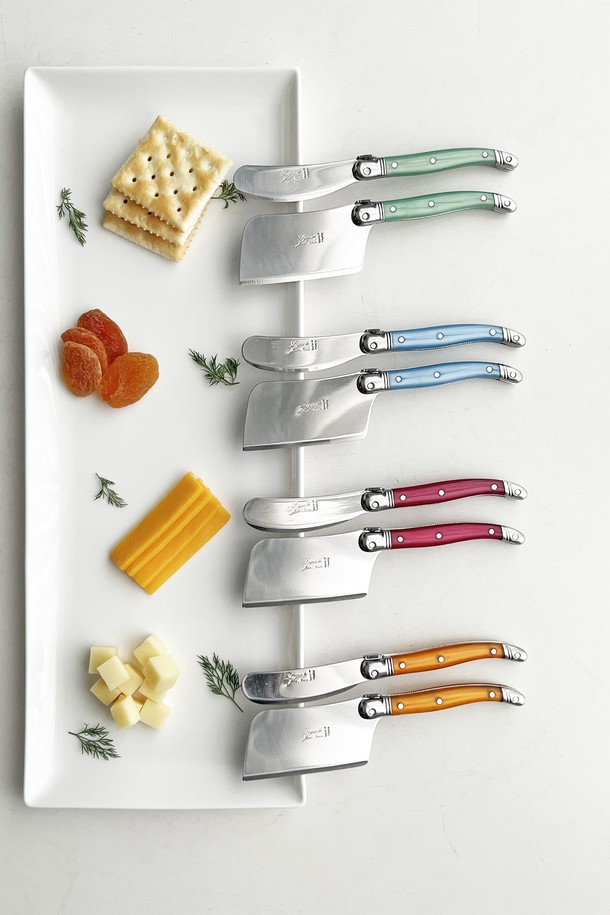 장네론 라귀올 버터나이프 & 치즈커터 세트는 주방을 더욱 특별하게 만들어 줄 세련된 커트러리 세트입니다. 12가지 다채로운 컬러(로즈, 오렌지, 옐로우, 그린, 블루, 프렌치블루, 마블베이지, 아이보리, 마블브라운, 올리브, 마블블랙, 블랙)로 출시되어 주방 인테리어에 포인트를 더합니다. 버터나이프와 치즈커터로 구성되어 있으며, 스테인리스 스틸, ABS 플라스틱, 올리브 우드 등 튼튼한 소재로 제작되어 뛰어난 내구성을 자랑합니다. 미세 톱니 형태의 날과 꿀벌 모양 장식, 곡선형 손잡이 디자인이 특징이며, 버터 및 치즈를 부드럽게 커팅할 수 있는 뛰어난 절삭력을 제공합니다. 우수한 그립감으로 편안하게 사용할 수 있으며, 테이블 세팅을 더욱 돋보이게 해줍니다.
